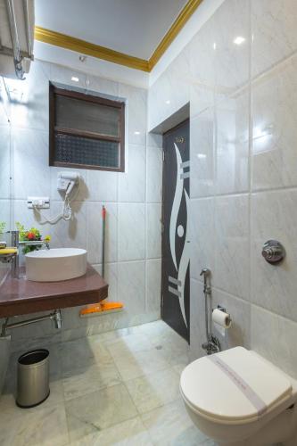 a bathroom with a toilet and a sink at Hotel Harmony in Khajurāho