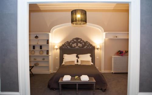 Un dormitorio con una cama grande y una lámpara de araña. en Chambres d'Hotes La Chartreuse des Eyres, en Podensac