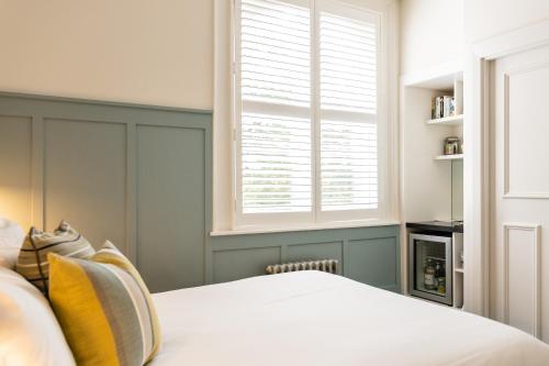 a bedroom with a white bed and a window at Didsbury House Hotel in Manchester