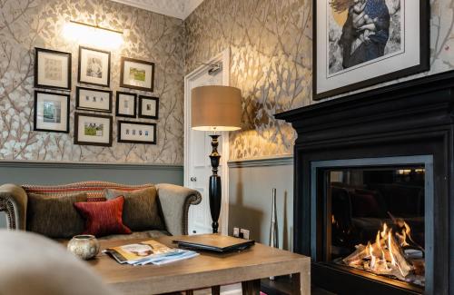 a living room filled with furniture and a fireplace at Didsbury House Hotel in Manchester