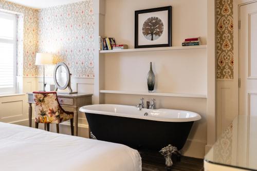 a bathroom with a sink, toilet, and bathtub at Didsbury House Hotel in Manchester