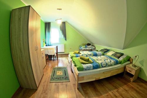 a bedroom with a bed in a green room at Domek Obidza 362 - Agroturystyka in Obidza