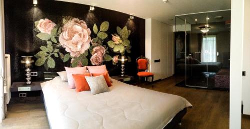 sypialnia z dużym białym łóżkiem z różowymi poduszkami w obiekcie Boutique Hotel Bersas w mieście Turaida