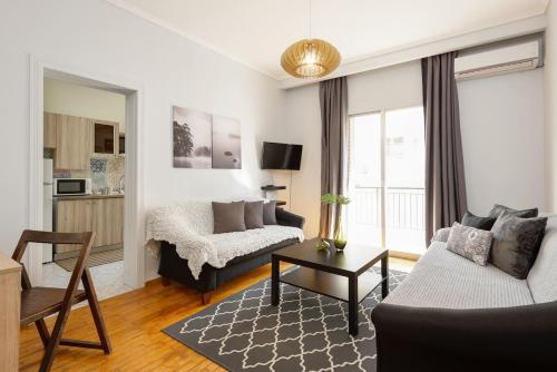 een woonkamer met een bank en een tafel bij Upscale and Spacious 3BR Home in Thessaloniki