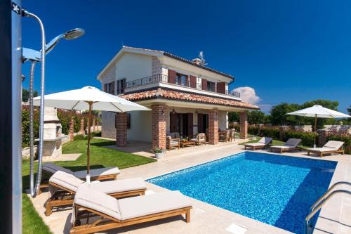 a villa with a swimming pool and a house at DeLuxe Villa Suza in Kras