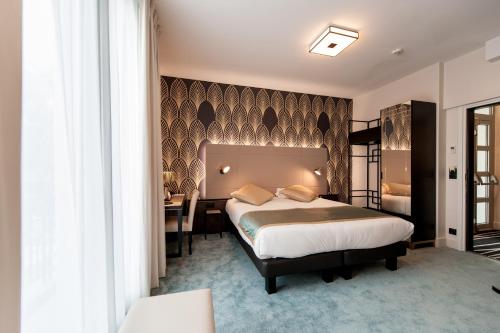 a bedroom with a bed and a desk and a table at Best Western Hôtel Journel Antibes Juan-les-Pins in Antibes