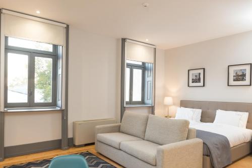 - une chambre avec un lit, un canapé et une chaise dans l'établissement FMO APARTMENTS BOAVISTA, à Porto