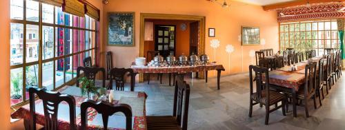 a restaurant with tables and chairs in a room at Hotel Harmony in Khajurāho