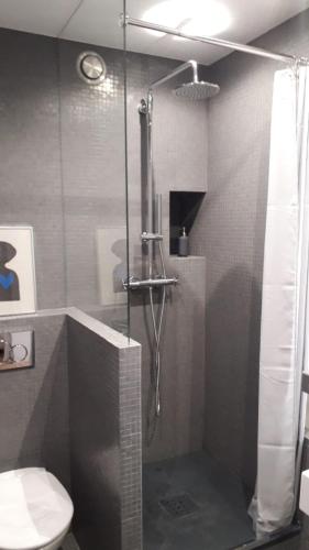 une douche avec une porte vitrée dans une salle de bain dans l'établissement Joie Paris TOUR EIFFEL, à Paris