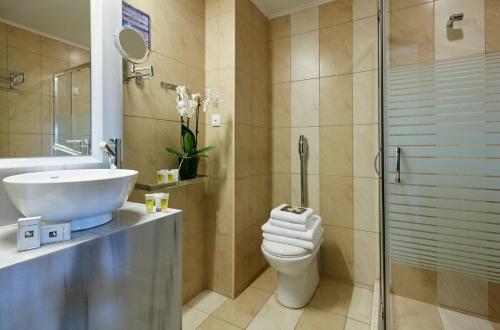 a bathroom with a toilet and a sink and a shower at Aar Hotel & Spa Ioannina in Ioannina