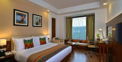 um quarto de hotel com uma cama grande e uma secretária em Fortune Park Orange, Sidhrawali - Member ITC's Hotel Group em Bhiwadi