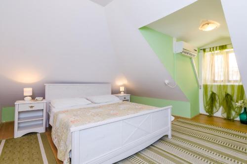 a bedroom with a white bed and a green wall at Old Town Baroque Palace Accommodation in Dubrovnik