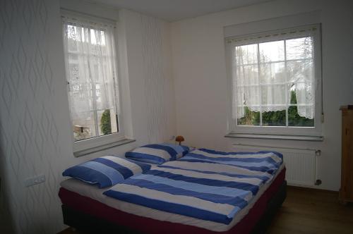 a bedroom with a bed with blue and white pillows at Pension Oberberg in Lindlar