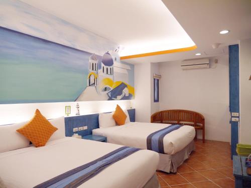 a hotel room with two beds and a painting on the wall at Kenting Sin Sin Hotel II in Kenting