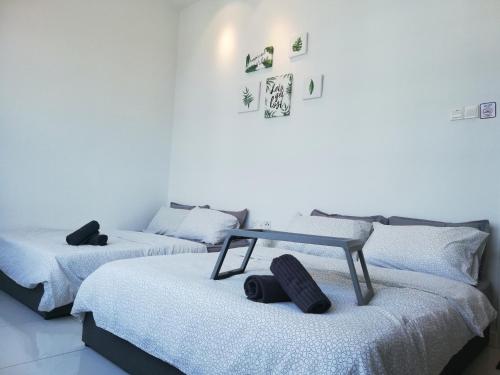 twee bedden in een kamer met een tafel bovenop bij Puchong Skypod Residence, 1-4pax unit, Walking Distance to IOI Mall, 10min Drive to Sunway in Puchong