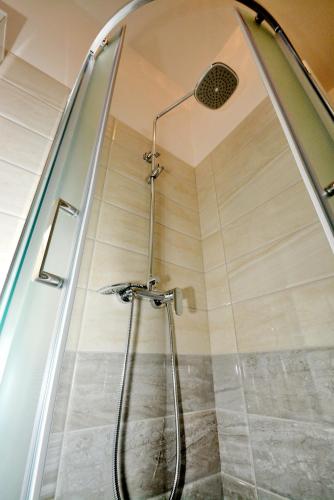 a shower with a glass door in a bathroom at Guesthouse Kamen Kuća in Podstrana