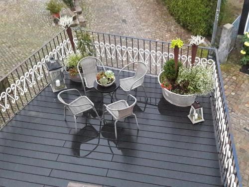 a balcony with chairs and potted plants on it at Fewo Froschkönig in Schieder-Schwalenberg