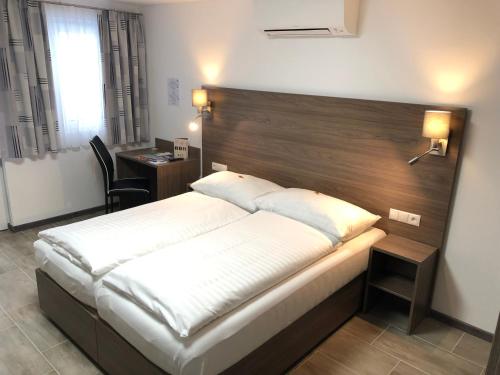 1 dormitorio con 1 cama grande y cabecero de madera en Hotel König en Viena