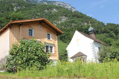 a church with a cross on the side of a building at Haus Bünten in Quinten