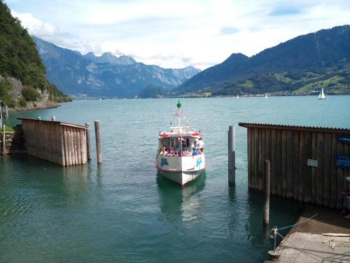a boat is docked at a dock in the water at Haus Bünten in Quinten