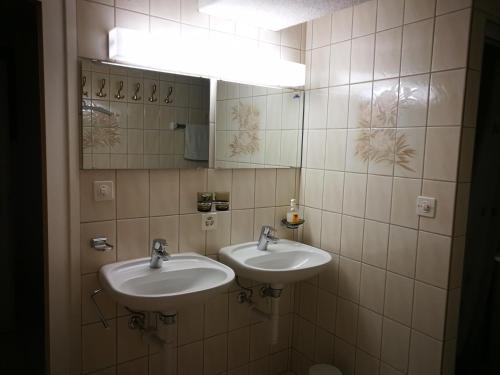 a bathroom with two sinks and a mirror at Haus Bünten in Quinten