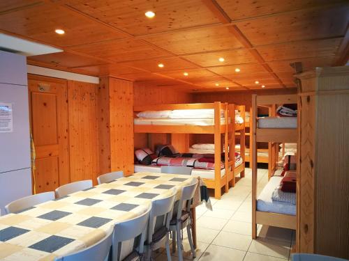 Zimmer mit einem Tisch, Stühlen und Etagenbetten in der Unterkunft Haus Bünten in Quinten