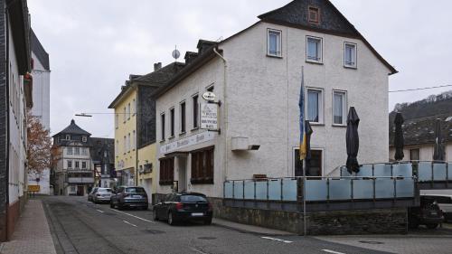 a building on a street with cars parked on the street at Hotel Deutsches Haus in Kaub