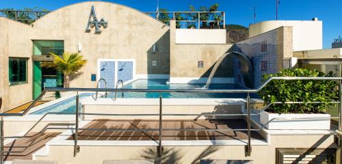 a house with a swimming pool in front of a building at Hotel Astoria Palace in Rio de Janeiro