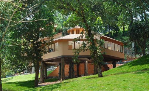 a house sitting on top of a hill with trees at Vythiri Village in Vythiri