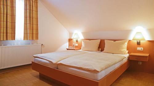 a bedroom with a large bed with two lamps at Hotel Deutsches Haus in Kaub