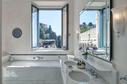 タオルミーナにあるGrand Hotel Timeo, A Belmond Hotel, Taorminaのバスルーム(シンク2台、窓2つ付きのバスタブ付)