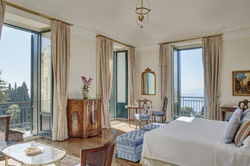 1 dormitorio con 1 cama y ventanas grandes en Grand Hotel Timeo, A Belmond Hotel, Taormina en Taormina