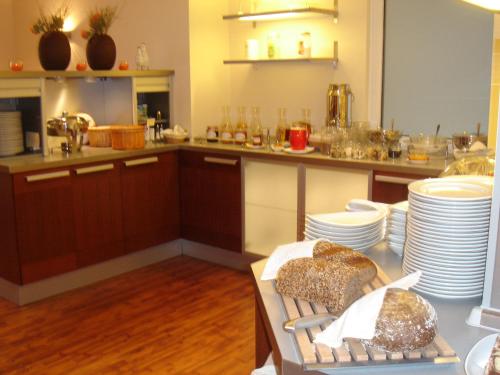 een keuken met een tafel met borden erop bij Aparthotel Christine in Bad Füssing