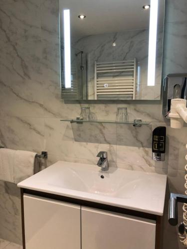 a bathroom with a white sink and a mirror at Hotel König in Vienna
