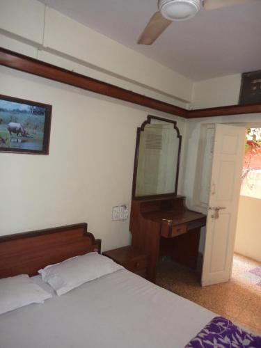a bedroom with a bed and a dresser and a mirror at HOTEL NEELKAMAL in Indore