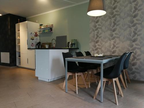 a kitchen with a table and chairs and a refrigerator at Gästewohnung Hygge in Oldenburg