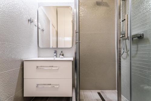 a bathroom with a sink and a mirror and a shower at Apartment Riverside Molnar26 in Budapest