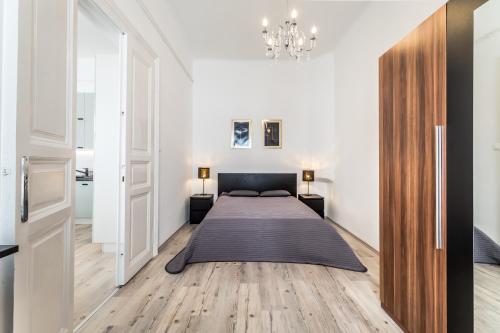 a bedroom with a bed and a chandelier at Apartment Riverside Molnar26 in Budapest