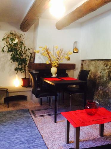 - un salon avec un piano et une table rouge dans l'établissement Fontaine-de-Vaucluse : maison avec vues, à Fontaine-de-Vaucluse