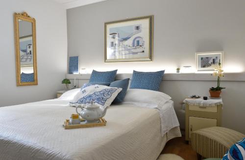 a bedroom with a large white bed with blue pillows at Residenza Aurora in Gradara