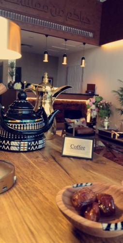 ein Tisch mit einer Kaffeekanne und einem Teller Essen in der Unterkunft شقق ملفاكم للشقق المخدومة in Riad