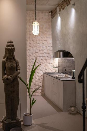a kitchen with a statue and a plant in a room at Mai Ram Yoga House in Vilnius