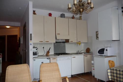 una cucina con armadietti bianchi ed elettrodomestici bianchi di appartamento Le Vele a Gargnano