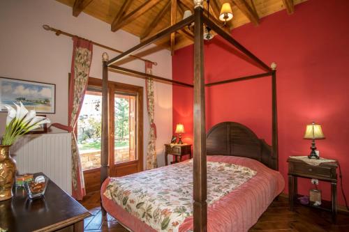 1 dormitorio con cama con dosel y paredes rojas en Luxury Villa Helios, en Koropi