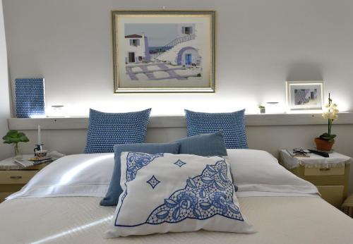 a bedroom with a bed with blue and white pillows at Residenza Aurora in Gradara