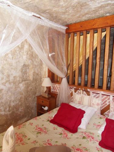 a bedroom with a bed with a canopy at Troglodelice in Azay-le-Rideau