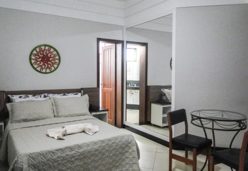 a bedroom with a bed and a chair and a mirror at Hotel Real in Teófilo Otoni