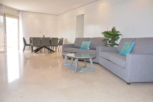 a living room with a couch and a table at Renovated 3 Bedroom - Residence with Pool next the Beach in Eilat