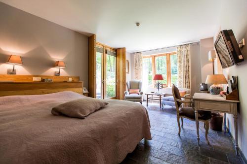 a bedroom with a bed and a desk and a desk at Relais & Chateaux Hotel Landgoed Het Roode Koper in Ermelo
