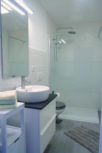a white bathroom with a sink and a shower at Ferienwohnung Häckel in Kurort Oberwiesenthal